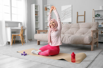 Poster - Muslim female fitness trainer exercising on yoga mat at home