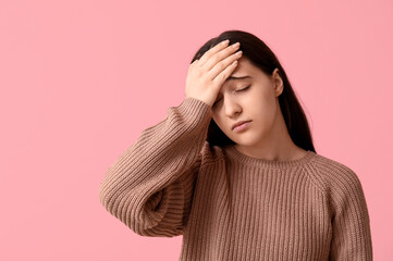 Canvas Print - Beautiful young woman suffering from headache on pink background