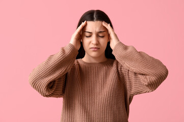 Canvas Print - Beautiful young woman suffering from headache on pink background