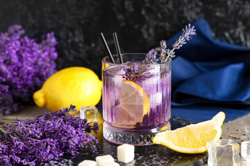 Wall Mural - Glass of fresh lavender lemonade with flowers and lemons on grey table