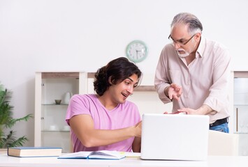 Wall Mural - Old father helping his son in exam preparation