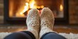 © DSimage - Feet in woolen socks by the Christmas fireplace. Winter and Christmas holidays background