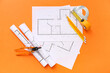 © Pixel-Shot - Architect's supplies with house plans on orange background