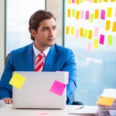 Wall Mural - Young handsome employee with many conflicting priorities