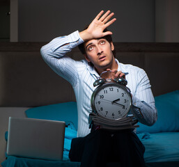 Wall Mural - Tired businessman working overtime at home at night