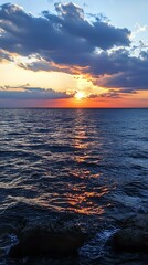 Wall Mural - Sunset over the Ocean with Clouds and Rocks