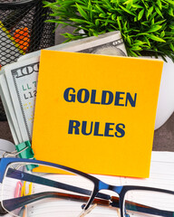 Wall Mural - Conceptual golden rule symbol. Copy space. GOLDEN RULES words on a yellow sticker on the table