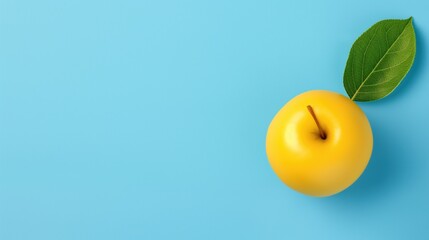 Flat lay blue background and ripe yellow apple with green leaf, top view poster.