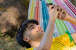 © carballo - young man or boy with mobile phone in summer lying in hammock