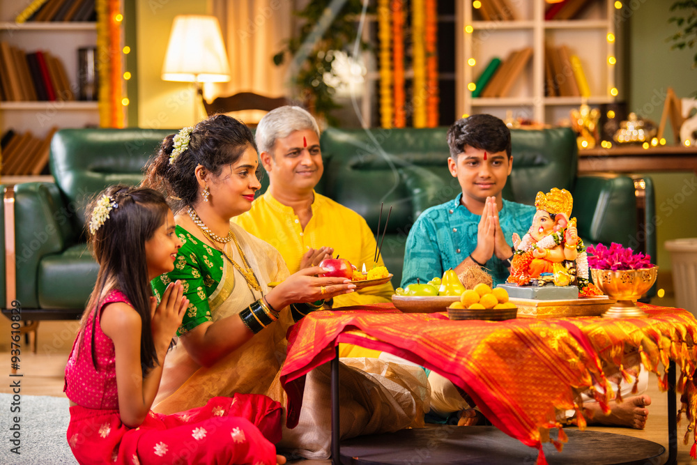 Indian family celebrating Ganesh Chaturthi, performing puja with ...