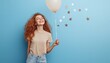 © Anastasia Knyazeva - Photo of an overjoyed girl dressed in a beige t-shirt, holding colorful balloons, with a bright smile, capturing a moment of pure happiness and celebration