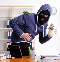 Wall Mural - Male thief in balaclava in the office