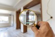 © DeepView - A person holding a magnifying glass, examining the new home interior in the middle of a construction site