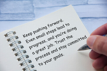 Motivational and inspirational or encouragement quote relating to progress and challenges written on notepad. Inspirational and encouragement concept