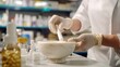 © MP_Artworks - A pharmacist prepares compounded medication using a mortar and pestle in a clean, professional pharmacy lab, emphasizing precision in custom pharmaceutical preparations.