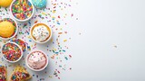 Colorful sprinkles and cupcakes on a white background.