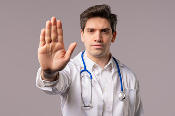 Serious american 30s doctor man showing rejecting gesture by stop hand palm sign