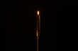© Gaetan - burning candle on black background. Dark candle burning on a candlestick.