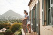 © Chanelle2000/peopleimages.com - Couple, balcony and view for travel, holiday and morning coffee with mountain, hug and bonding in Italy. Man, woman and adventure together for vacation in luxury hotel for love, relax and anniversary