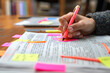© Degimages - Editor marking corrections on printed manuscript, red pen and post-it notes in hand.