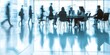 © kwanchaift - Blurred businesspeople in a contemporary office meeting room, with focus on the large glass table and sleek chairs, corporate minimalism