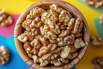 Close-up of fresh walnuts in wooden bowl on colorful background