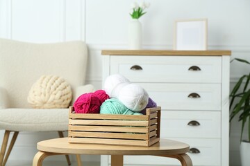 Wall Mural - Wooden crate with different yarns on coffee table indoors