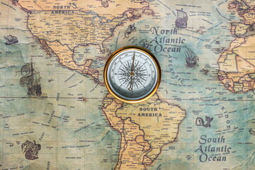 Classic round compass on background of old vintage map