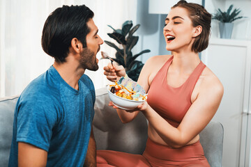 Healthy sporty and vegetarian couple in sportswear with a bowl of fruit and vegetable. Healthy cuisine nutrition and vegan lifestyle for fitness body physique at gaiety home concept.