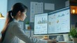 © Dalidudko - a young businesswoman seated at a desk in a modern office, deeply engrossed in monitoring a large computer screen displaying an array of colorful graphs and charts, suggesting a financial or analytica