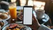 © PalaG - Morning Routine - Person Checking White Screen Mobile Phone While Having Breakfast at Home