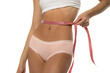 © vladimirfloyd - Woman measures naked waist with tape on white background