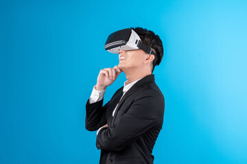 Wall Mural - Smiling Asian businessman looking thorough VR connecting to business world report in futuristic metaverse, analyzing innovation technology ads in virtual reality isolated blue copyspace. Contrivance.