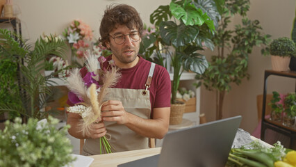 Poster - A young man with a beard arranging flowers at an indoor floral shop, showcasing a vibrant and green environment.