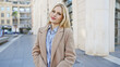 © Krakenimages.com - A young, attractive, blonde woman poses outdoors on an urban city street, embodying style and casual beauty.
