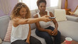 © Krakenimages.com - Women friends sitting together in a living room, one pointing the remote at the screen while talking