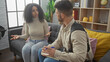 © Krakenimages.com - A woman converses with a man carrying a badge in a cozy living room, suggesting an informal investigation.