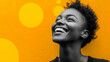 © Vivid_Vision - A smiling black woman with short hair, set against a yellow background with yellow circles.