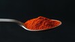 © Mickey - A close-up image of a spoonful of red spice against a black background. The vibrant color of the spice symbolizes passion, heat, energy, and flavor. The black background highlights the red spice, crea