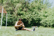 © qunica.com - Fit strong male sports person working out in park, stretching in nature. Demonstrating outdoor fitness and healthy lifestyle.