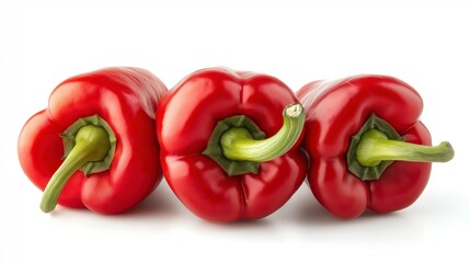 Three red bell peppers with green stems, isolated on white background.