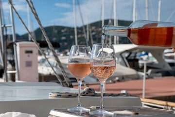 Party with rose wine on yacht boat anchored in port la Rague, Gulf of La Napoule, in Provence, two glasses of cold rose wine, French Riviera near Cannes, south of France