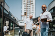 © qunica.com - Business professionals engaged in conversation and holding documents in a modern urban city setting, reflecting productivity and professional networking.