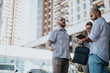 © qunica.com - Team of marketing professionals in an outdoor meeting discussing campaign performance, market trends, and strategy development. Business discussion in an urban setting.