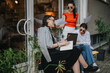 © qunica.com - Three businesswomen collaborating in an outdoor meeting as they discuss documents and take notes