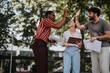 © qunica.com - Diverse colleagues outdoor high five celebrating success. Business meeting teamwork concept with happy team members.