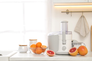 Canvas Print - Modern juicer and grapefruits on white counter in kitchen