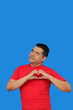 © Arlette - Dark-skinned Latino adult man makes a heart sign with his fingers as a sign of love and affection