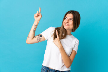 Young slovak woman isolated on blue background pointing with the index finger a great idea