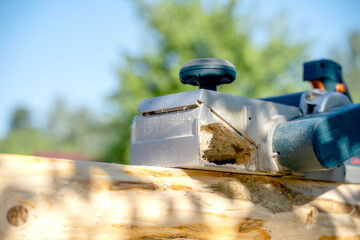 a carpenter works with an electric pipe on a sunny day